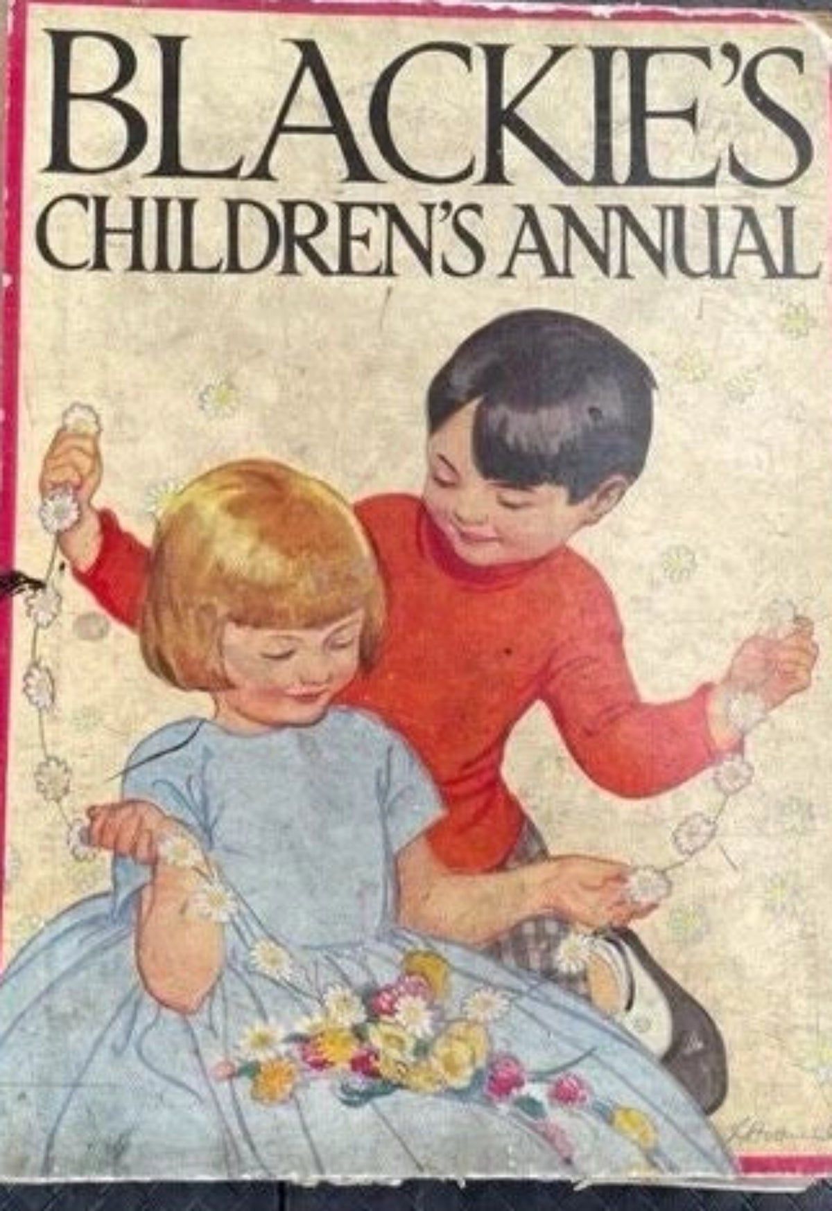 Vintage children's book titled 'BLACKIE'S CHILDREN'S ANNUAL' with an illustrated cover showing two children, photographed on a dark textured surface.